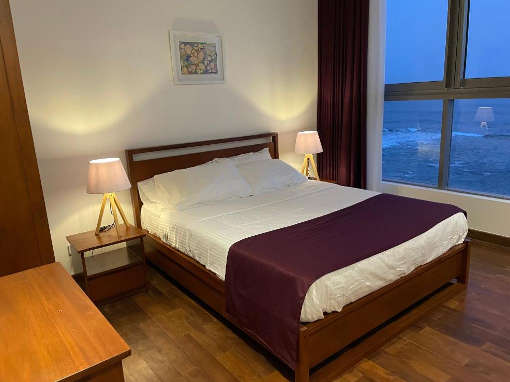 una camera da letto con un letto con due lampade e una finestra di Apartment L4-5, Oceanfront Condos, Galle, Sri Lanka a Galle