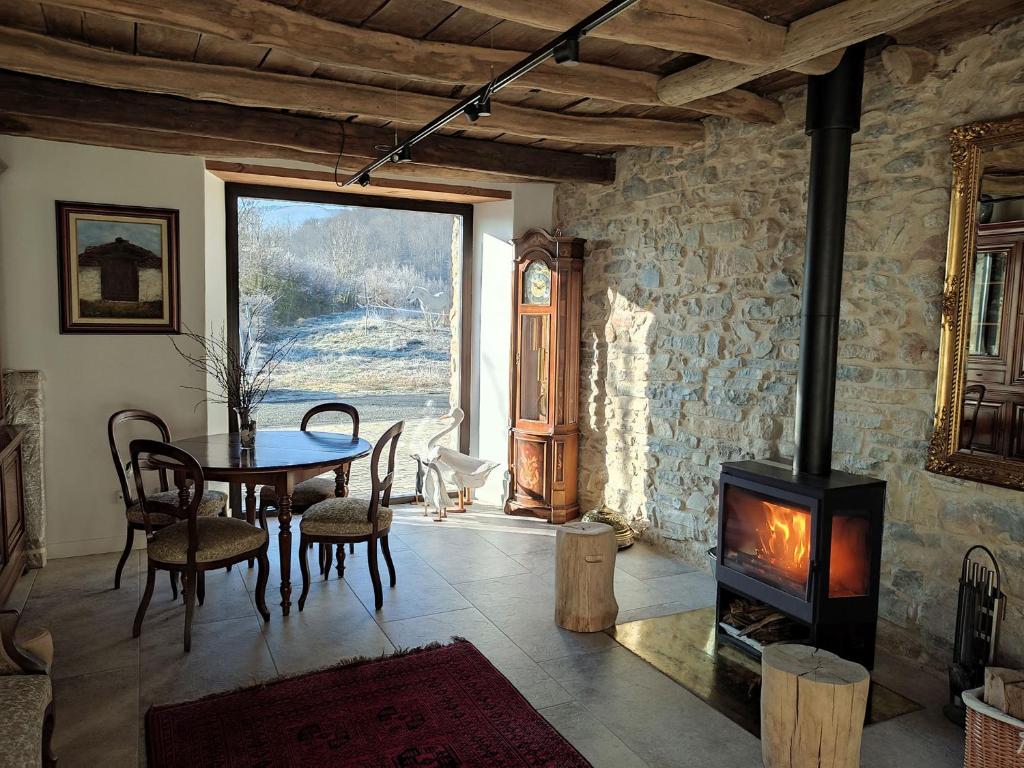 sala de estar con mesa y estufa de leña en Mokorroko Borda Hostal Rural, en Echalecu