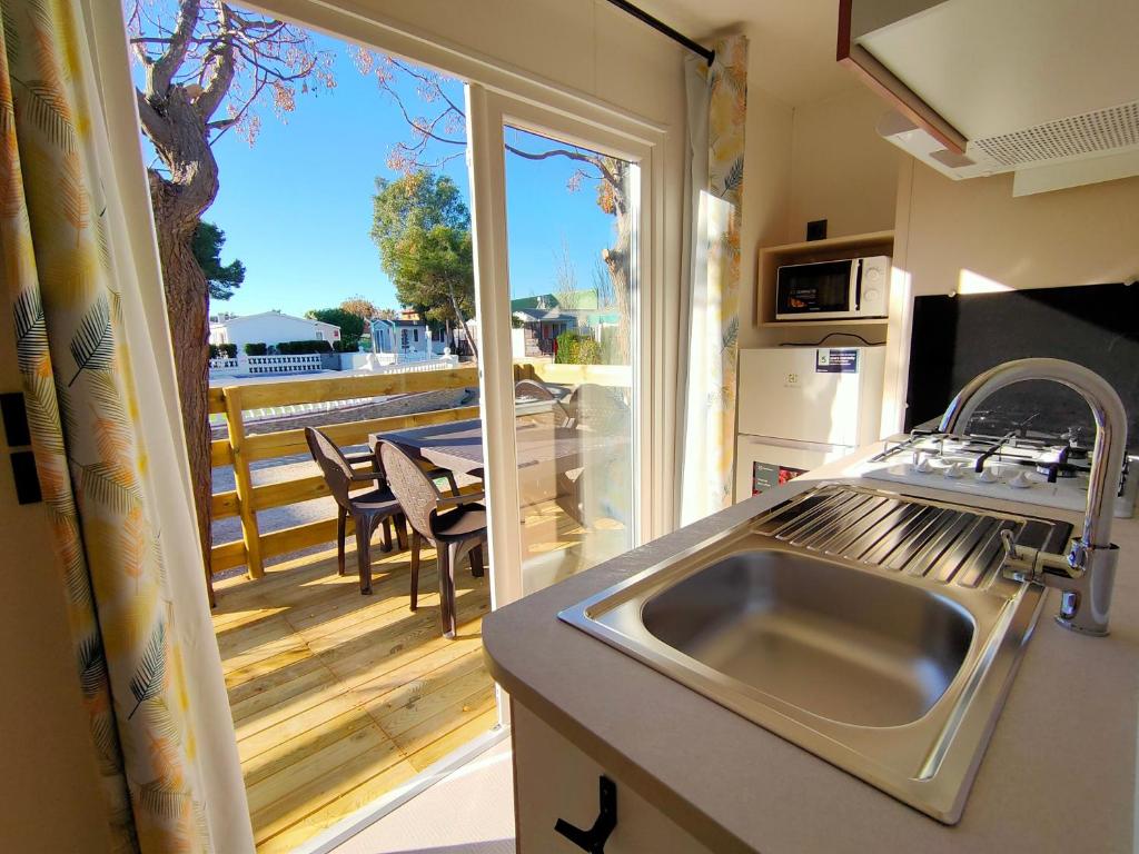 a kitchen with a sink and a view of a balcony at Camping Valencia el Saler in El Saler