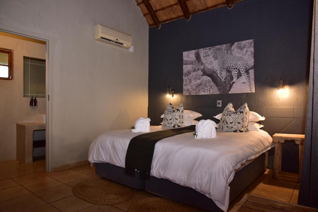 a bedroom with a large bed with white sheets and pillows at Bayala Private Safari Lodges in Hluhluwe