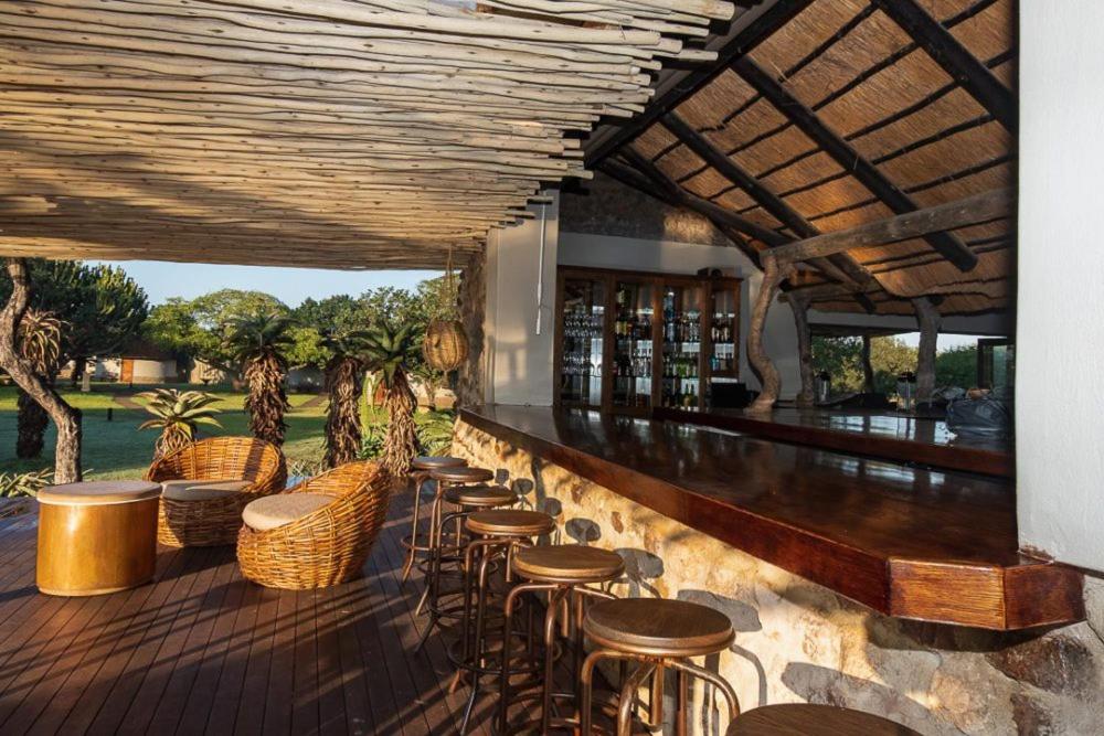 a bar with stools and tables on a deck at Bayala Private Safari Lodges in Hluhluwe