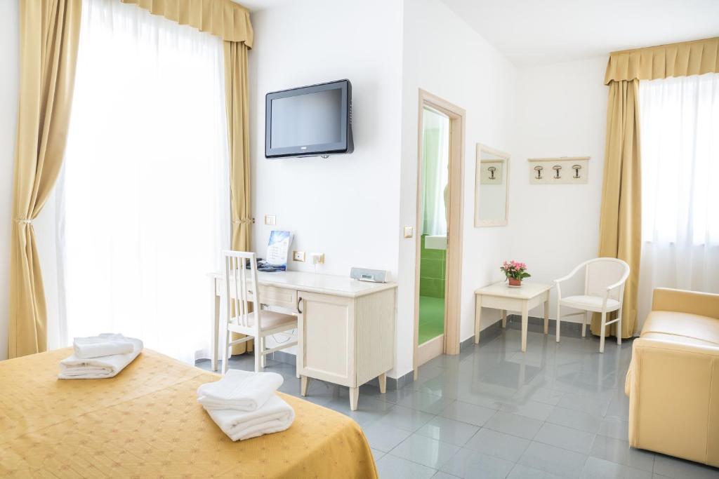 a hotel room with a bed and a desk at Hotel Marechiaro - Direttamente sul mare in Vico del Gargano