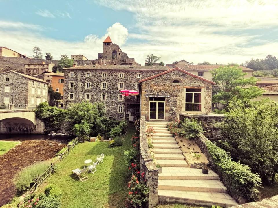 a stone building with stairs leading up to a building at Auberge de Chanteuges in Chanteuges