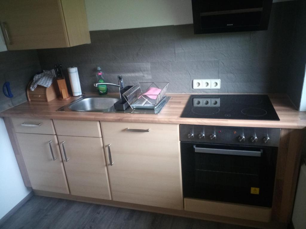 a kitchen with a stove and a sink at Ferienwohnung im idyllischen Neckartal in Starzach