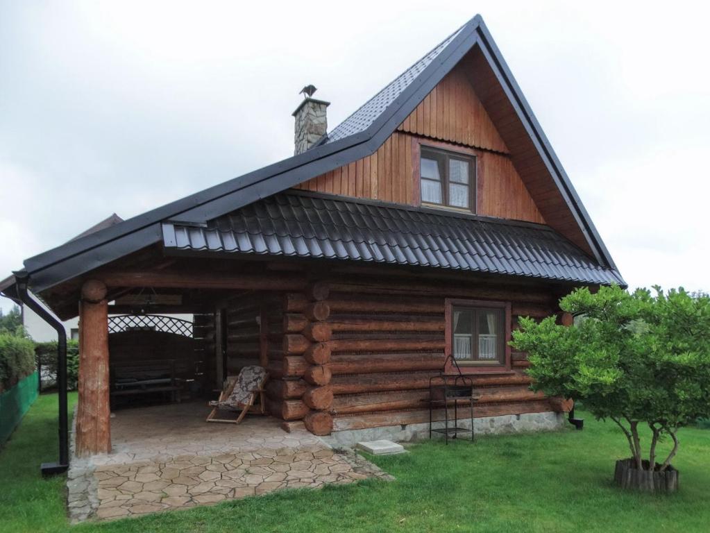 a log cabin with a gambrel roof at Domek Z Bali Góral in Kopalino