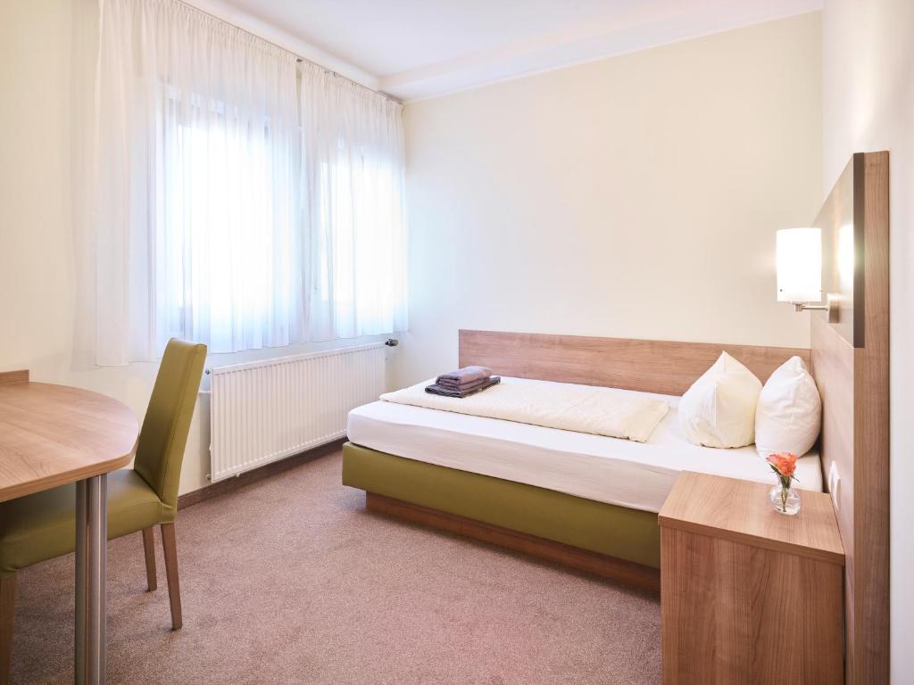 1 dormitorio con cama, escritorio y ventana en Portofino, en Bonn