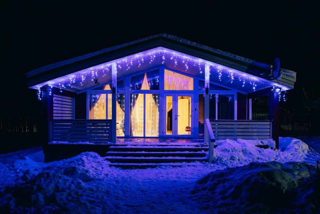 a house covered in christmas lights in the snow at Nikitskoe Podvorie in Pereslavl-Zalesskiy