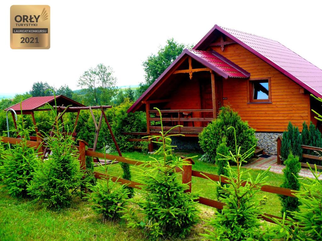 een houten hut met een hek ervoor bij Agroturystyka ZIELONA ZAGRODA w Kosztowej in Dubiecko