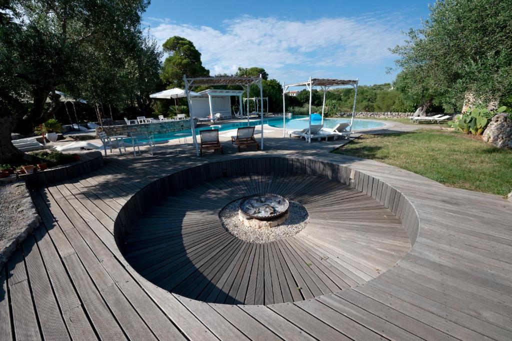a pool with a fire pit in the middle of a wooden deck at Masseria Trulli&Stelle B&B in Noci