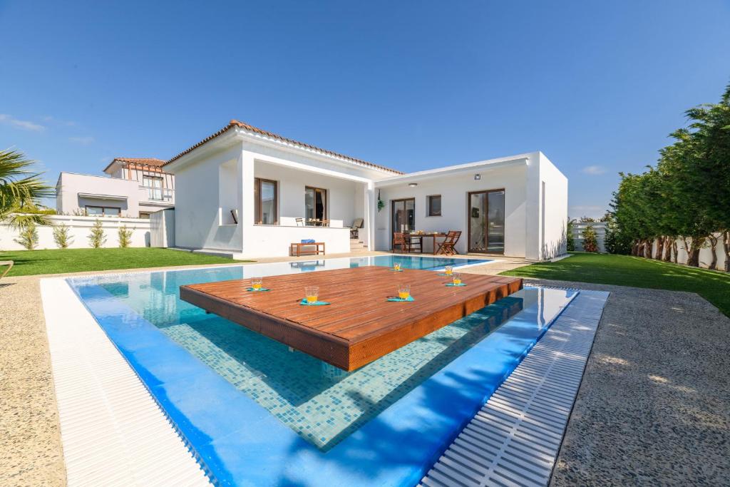 a villa with a swimming pool in front of a house at Napa Sunlight Villa #1 in Ayia Napa