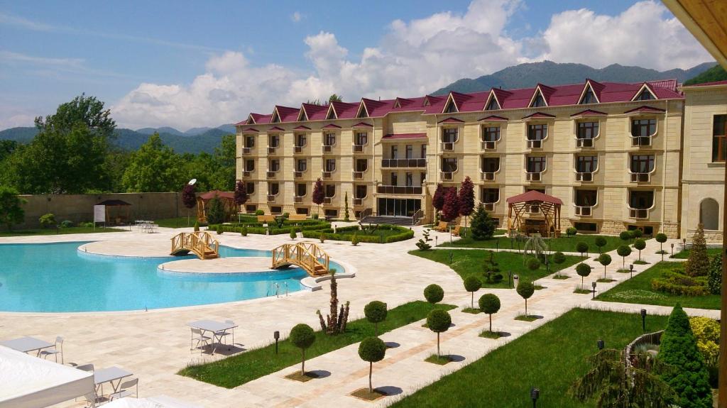 ein Hotel mit einem Pool vor einem Gebäude in der Unterkunft Gabala Yeddi Gozel Hotel in Qəbələ