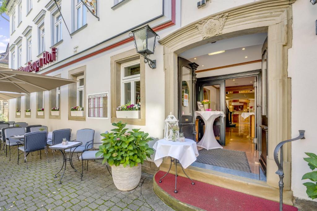ein Restaurant mit Tischen und Stühlen vor einem Gebäude in der Unterkunft Hotel Württemberger Hof in Öhringen