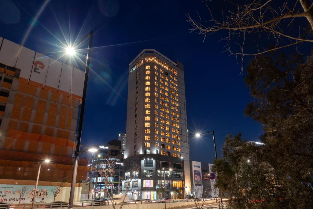 高陽的住宿－Urban-Est Hotel，一座高大的建筑,晚上有灯