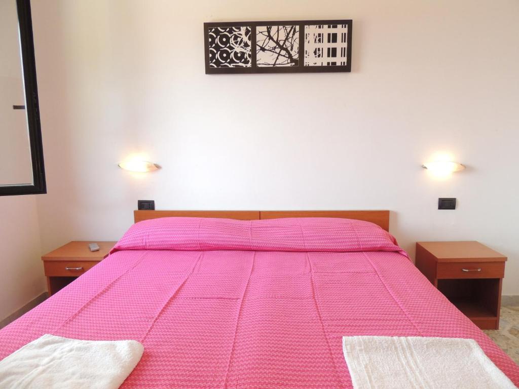 a bedroom with a pink bed with two night stands at Albergo Il Terrazzino in Vibo Valentia Marina