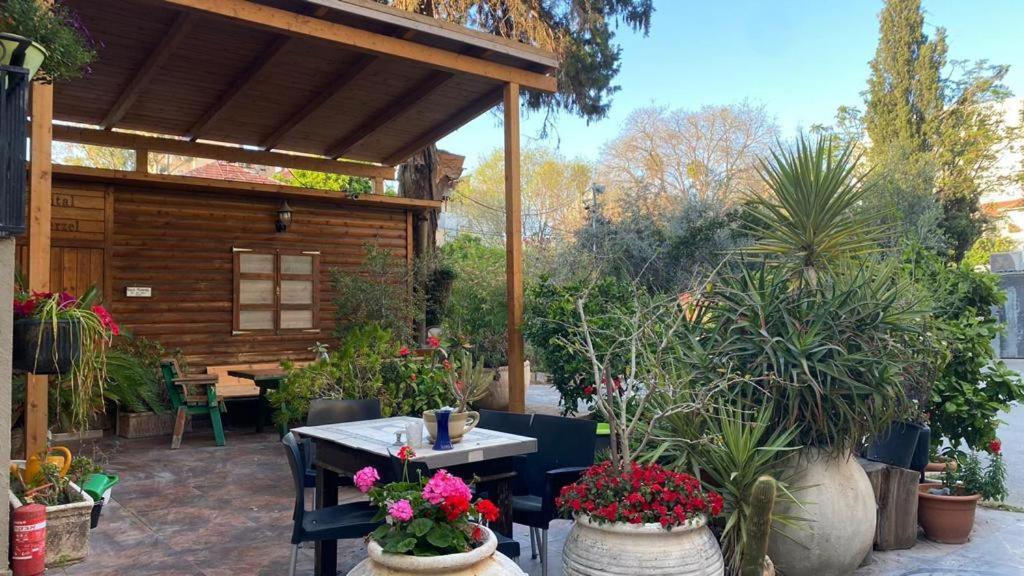 a patio with a table and some potted plants at Hotel Rehovot in Rechovot