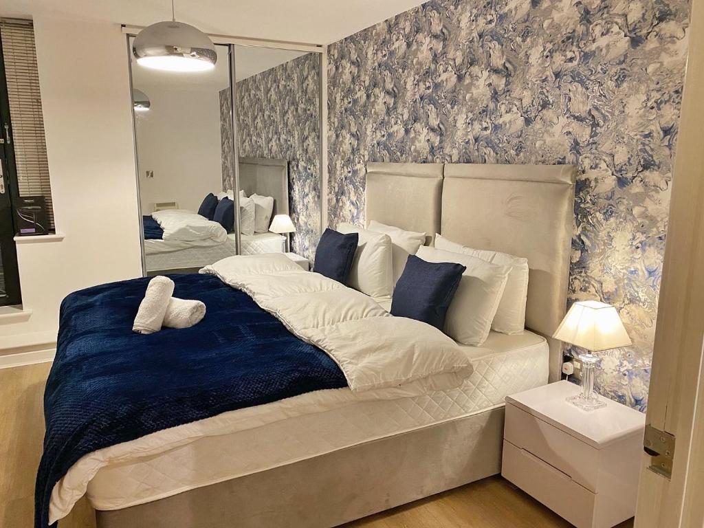 a bedroom with a large bed and a mirror at Perfect for Families & Business - Demha Nights in Birmingham