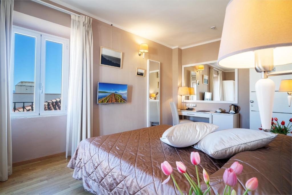 a bedroom with a bed with pink flowers on it at Hotel Centrale in Olbia