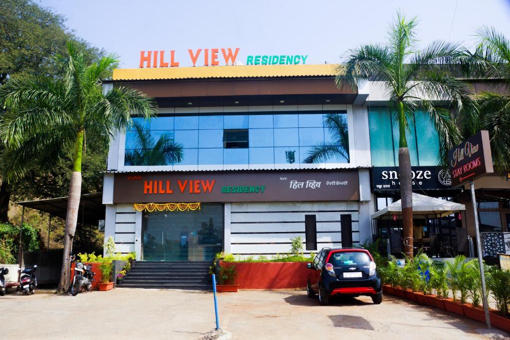 a building with a car parked in front of it at VIJAYA HILL VIEW RESIDENCY in Navi Mumbai