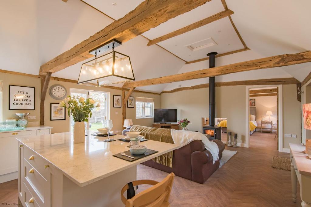 a kitchen and living room with wooden beams at Cart Lodge by Bloom Stays in Groombridge