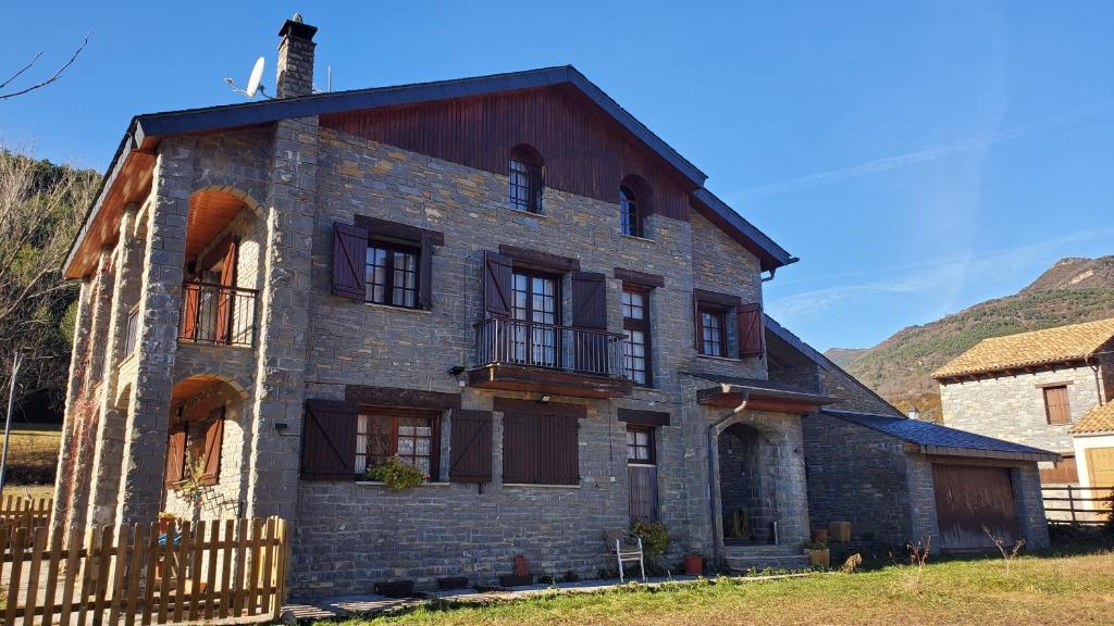 uma antiga casa de tijolos com janelas e uma cerca em Balcón de la Peña Cancias em Fiscal