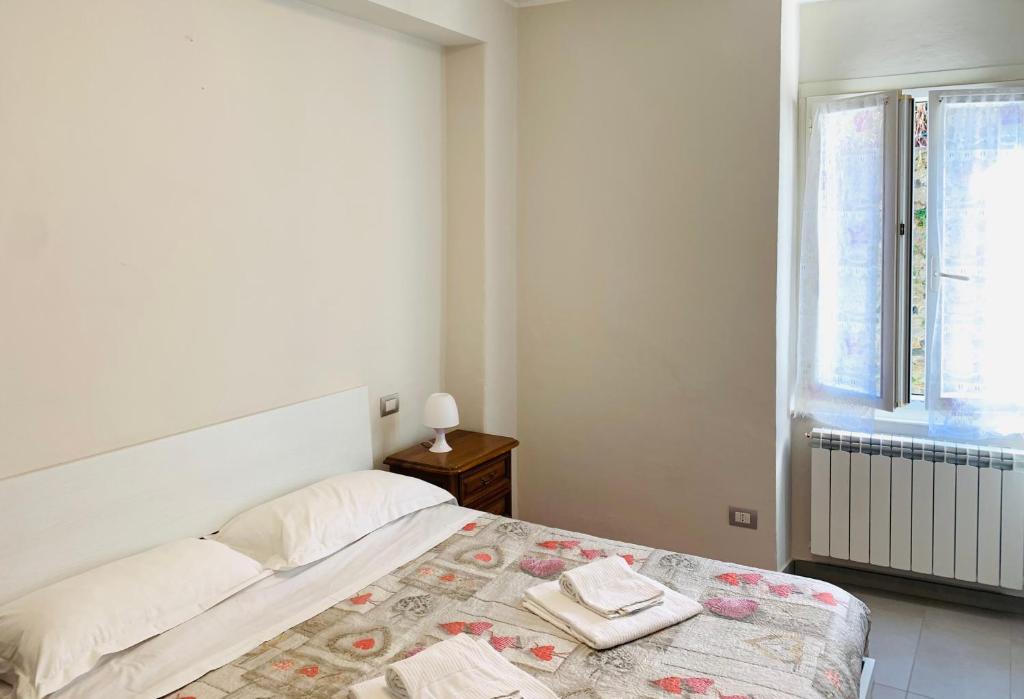 een witte slaapkamer met een bed en een raam bij Appartamenti Sant Andrea in Levanto