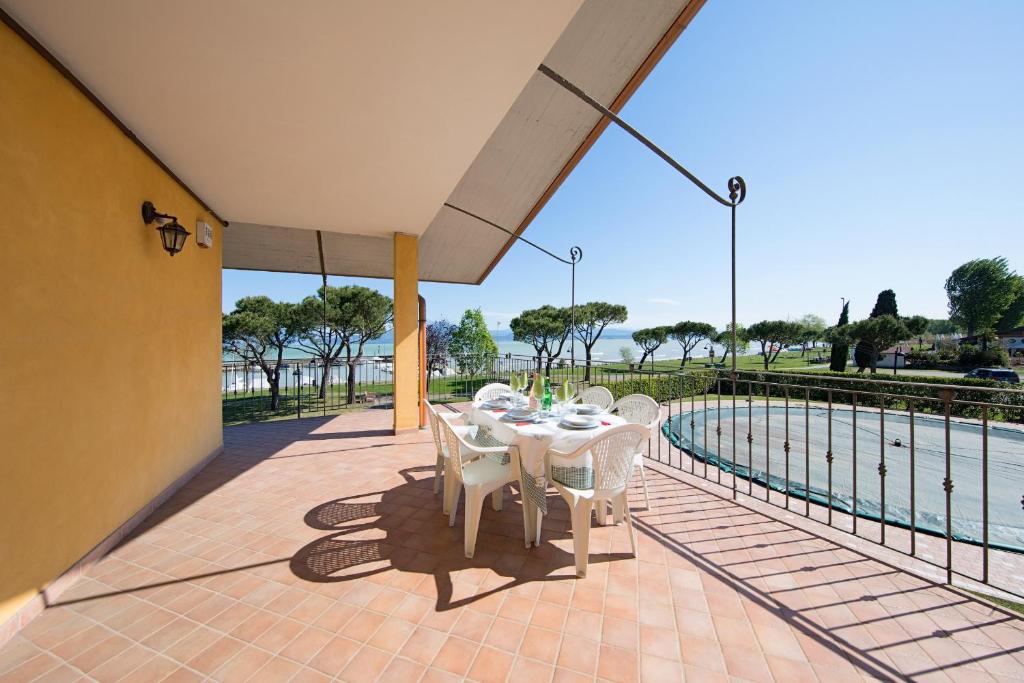 - une table et des chaises sur une terrasse à côté de la piscine dans l'établissement I Mosaici Apartments by Wonderful Italy, à Sirmione