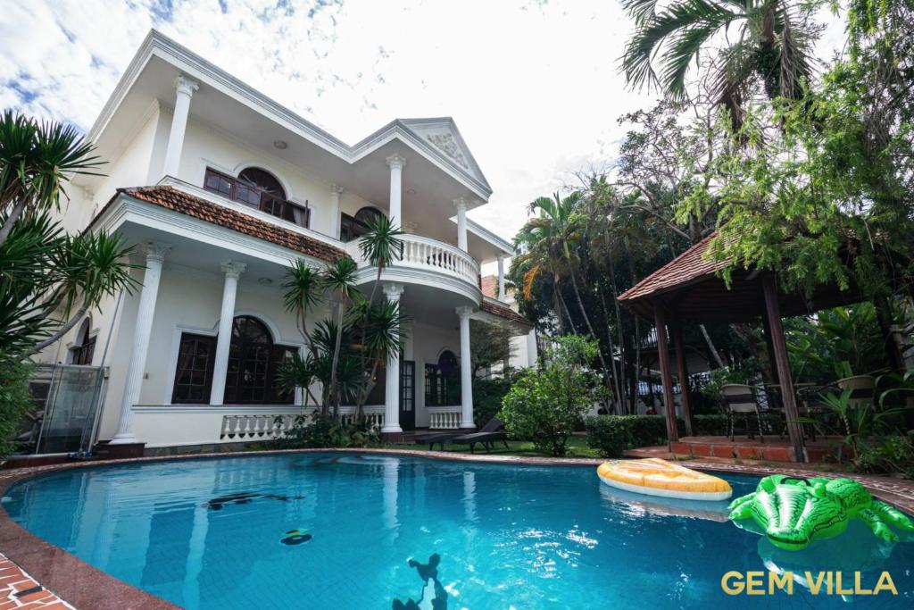 a large swimming pool in front of a house at GEM VILLA 10 - 5 Bedroom, 6 Bathroom, Big Pool, Big Garden in Ho Chi Minh City