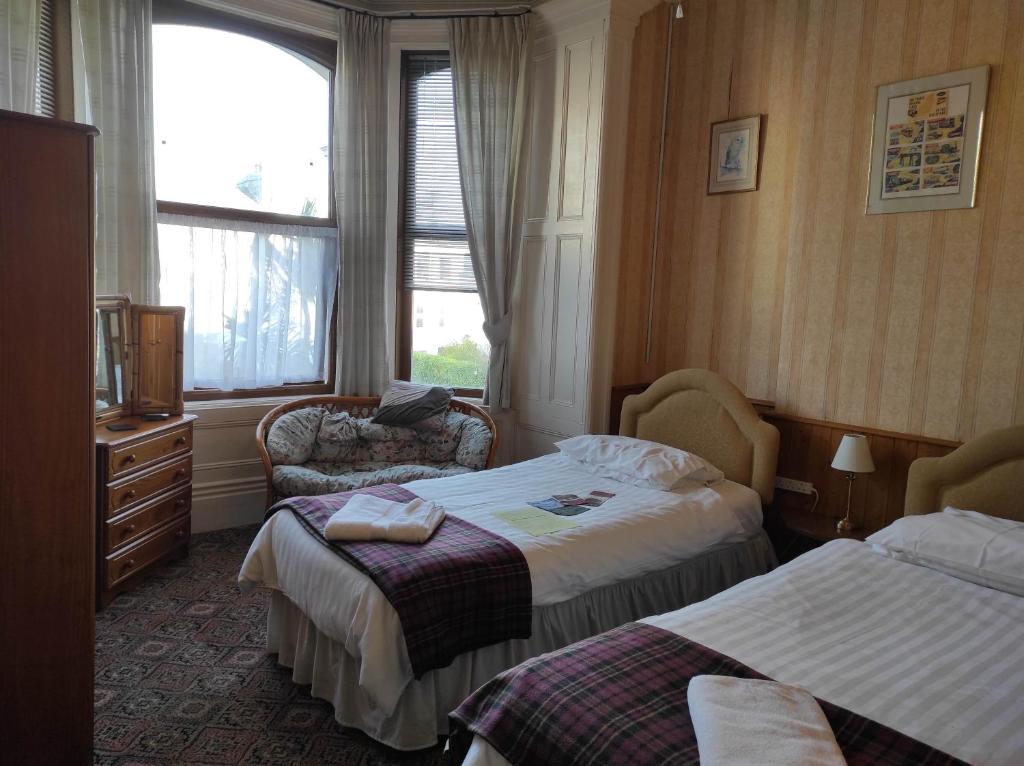 a hotel room with two beds and a window at All Seasons Guesthouse in Douglas