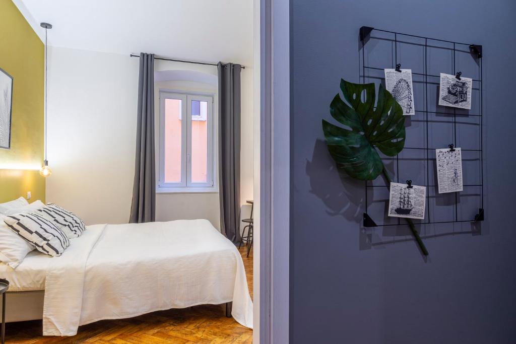 ein Schlafzimmer mit einem Bett und einer Pflanze an der Wand in der Unterkunft Brand new guest room with Wi-Fi in the city center in Triest