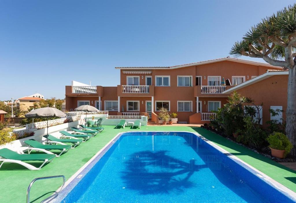 un complexe avec piscine et chaises longues dans l'établissement Parque Las Flores, à Puerto de la Cruz