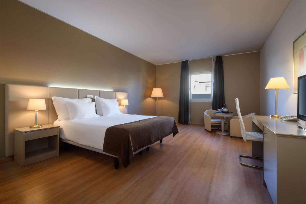 a hotel room with a bed and a desk at TRYP by Wyndham Porto Centro Hotel in Porto