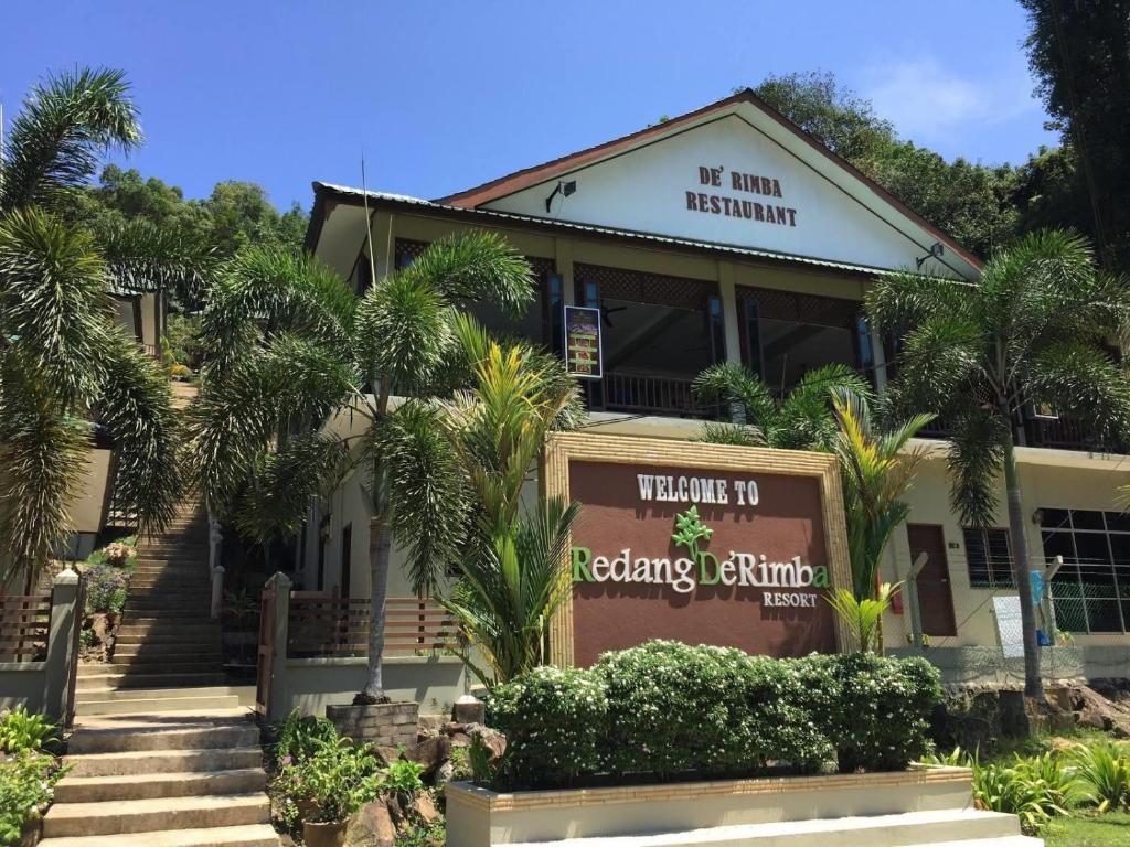 a building with palm trees in front of it at Redang De' Rimba in Redang Island