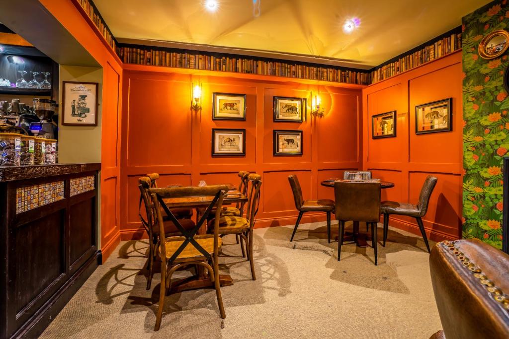a bar with orange walls and chairs and a table at The Crown Hotel in Glastonbury