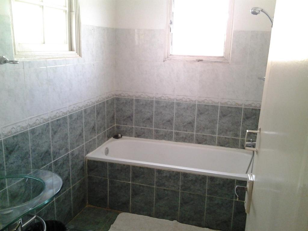 a bathroom with a tub and a sink and a window at B&B Au Triporteur in Antananarivo