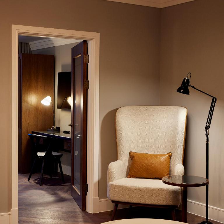 a living room with a chair and a desk at The Parkgate Hotel in Cardiff