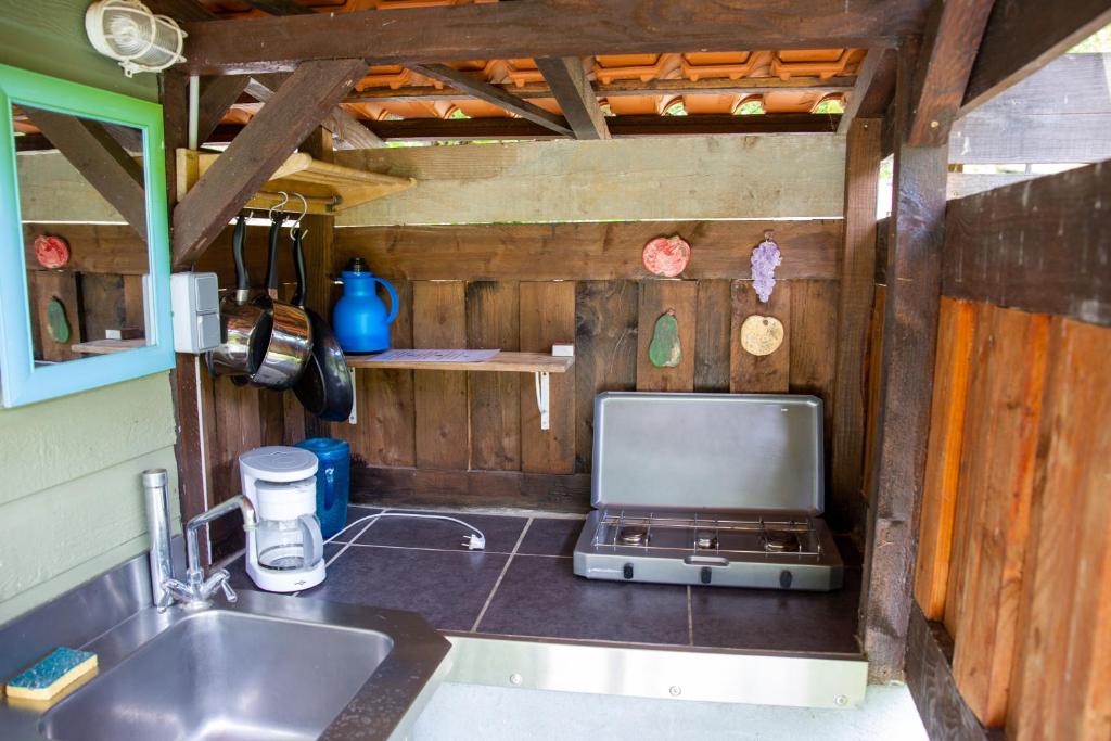 a kitchen with a sink and a stove top oven at pipowagen Blagour midden in de natuur in Lachapelle-Auzac
