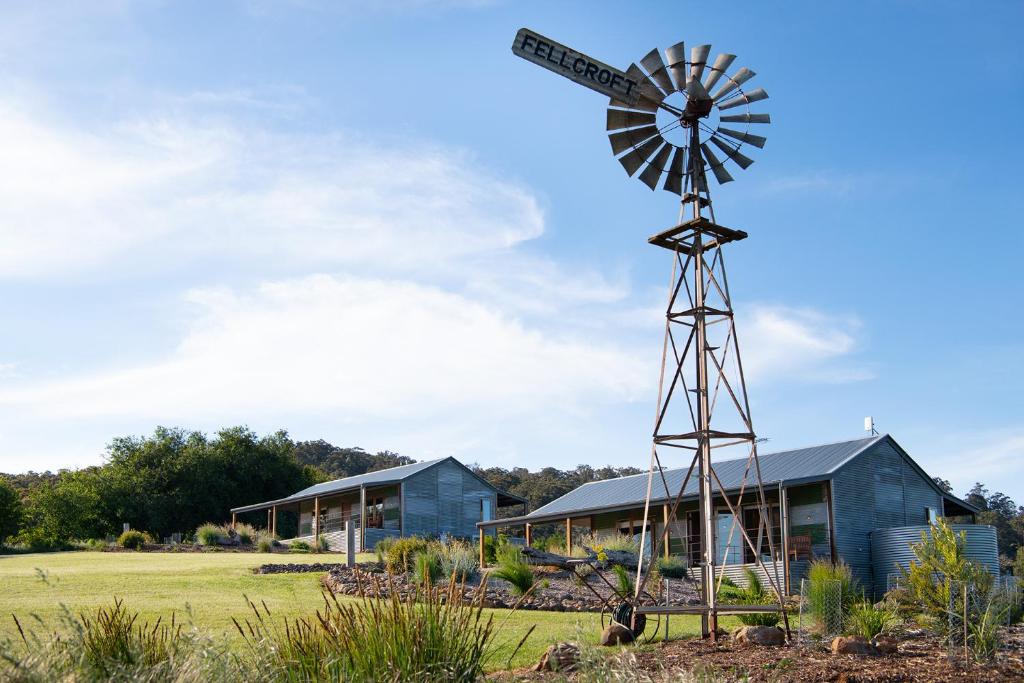 a windmill sitting in front of a building at Fellcroft Farmstay in Cobaw