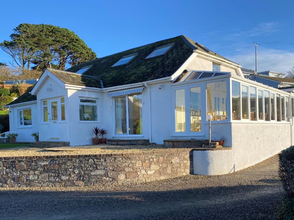 una casa blanca con muchas ventanas en Surf View en Woolacombe