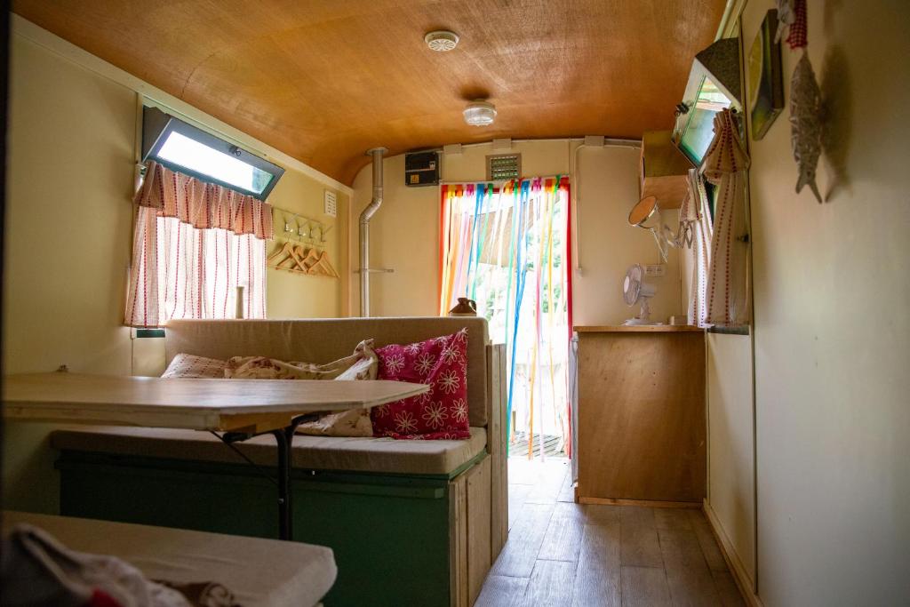 a room with a couch and a table in a train at pipowagen Blagour midden in de natuur in Lachapelle-Auzac