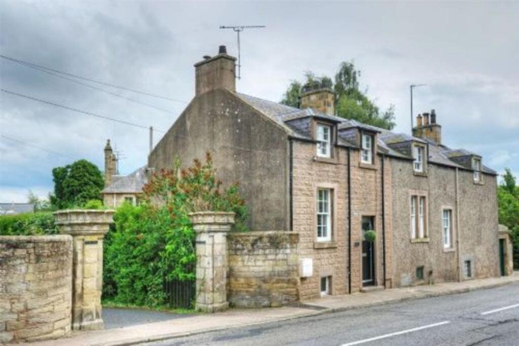 an old brick house on the side of a street at Goshen Cottage in Kelso