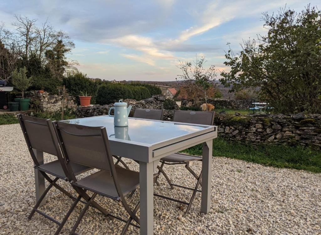 une table et des chaises blanches sur une terrasse en gravier dans l'établissement LE PARDÈS BnB, à Rocamadour