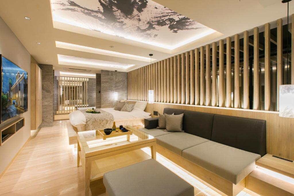 uma sala de estar com um sofá e uma mesa em HOTEL 粋 em Fukuyama