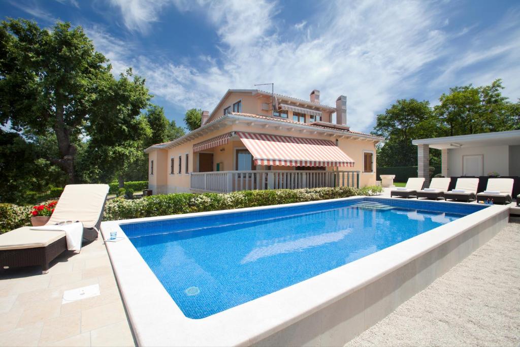 a villa with a swimming pool in front of a house at Villa Rosa in Labin