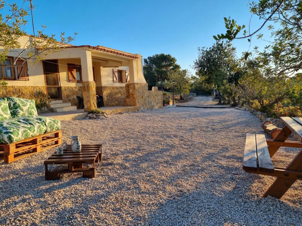 una casa con un sofá y una mesa delante en Finca Llambrich, en L'Ametlla de Mar