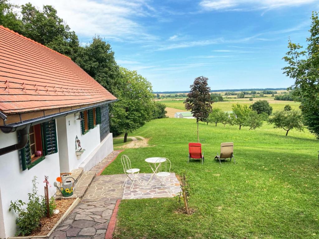 ein Haus mit einem Garten mit Stühlen und einem Tisch in der Unterkunft Kellerstöckl Weber in Güssing