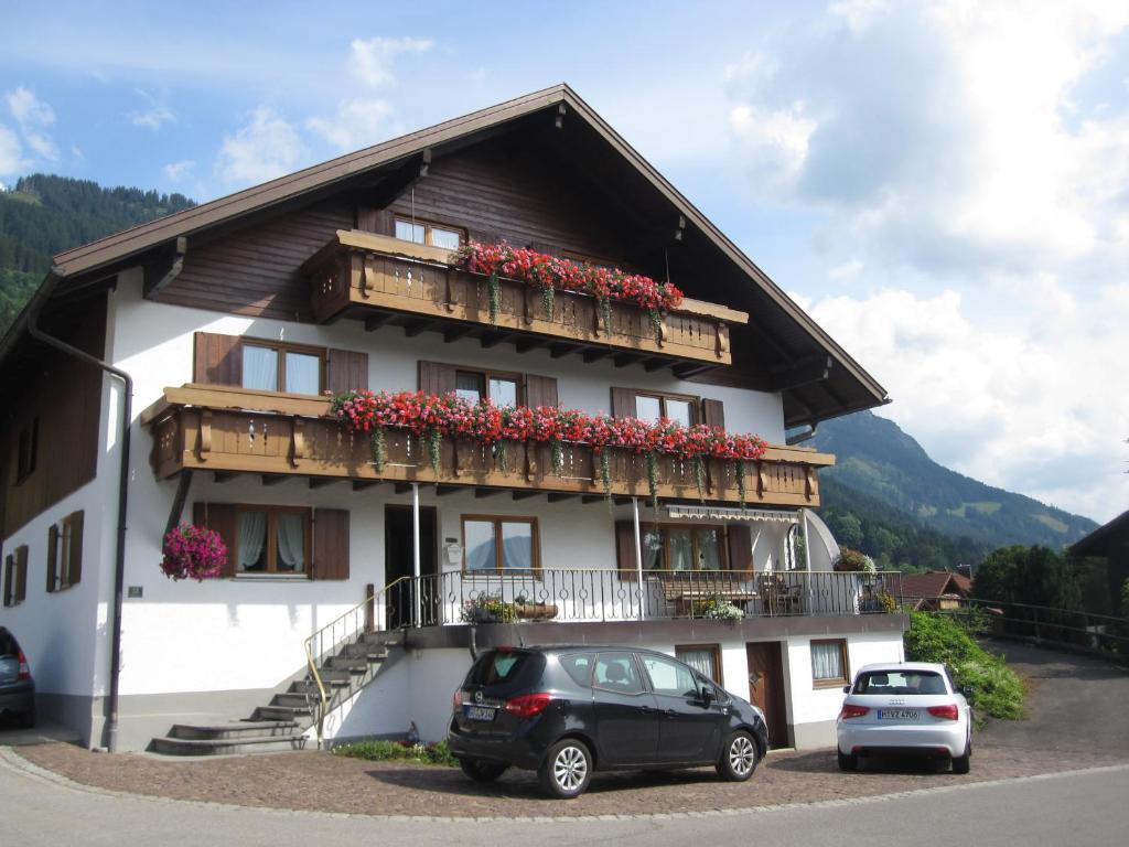 ein Gebäude mit einem Balkon mit Blumen darauf in der Unterkunft Gästehaus Bach in Oberstdorf