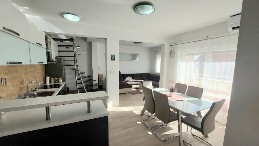 una cucina e un soggiorno con tavolo e sedie di Apartment Palada a Kaštela (Castelli)