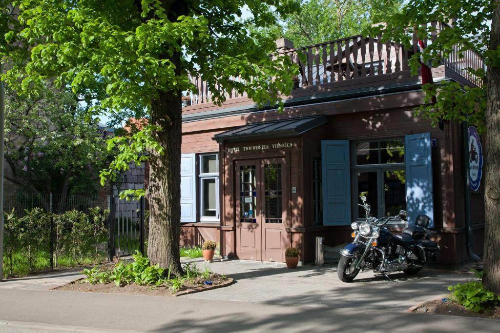 una motocicleta estacionada frente a un edificio en Two Wheels, en Riga