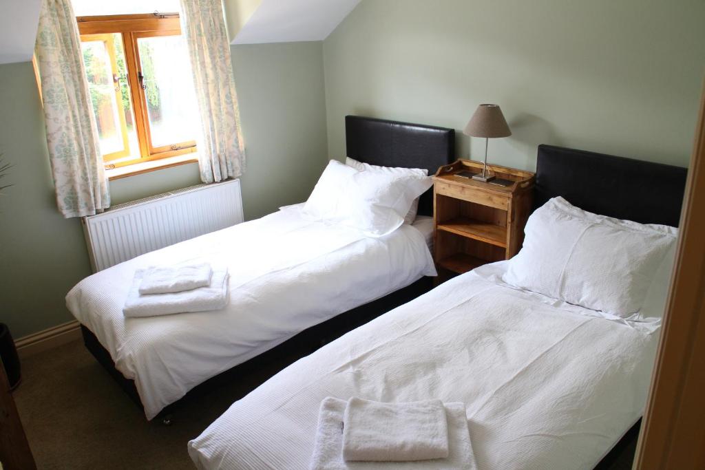 2 letti posti uno accanto all'altro in una camera da letto di Penrith Lodge a Stroud