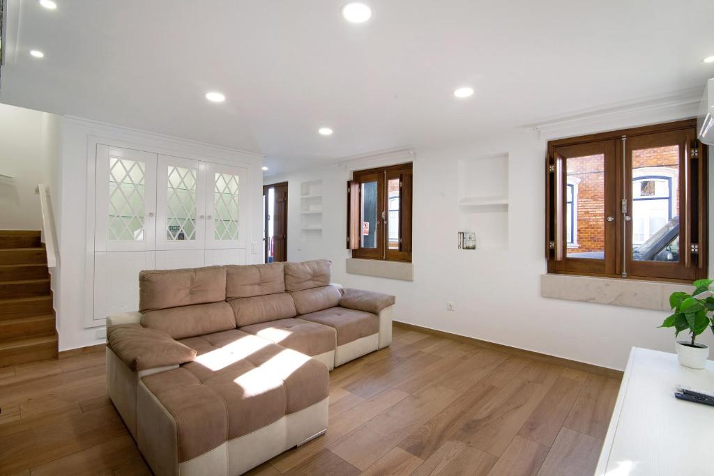 a living room with a couch and some windows at Casa do Marquês in Vila Real de Santo António